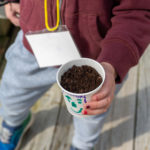 Child holding their cup with seed planted