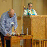 Don lighting the candles for joys and sorrows as Rev. Heather watches