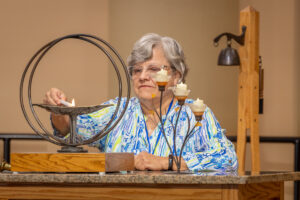 Pam Everrett lights the Chalice.