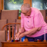 Jean Charles, Worship Associate, lights the candles for Joys and Sorrows.