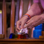 Closeup: Jean Charles, Worship Associate, lights the candles for Joys and Sorrows.